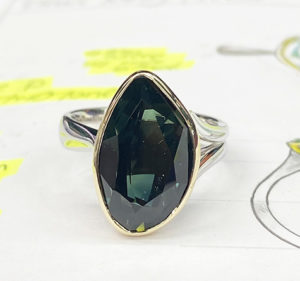 free form Australian sapphire ring front view sitting on the original design drawing